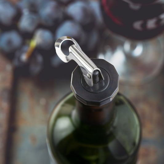 Close-up of a green wine bottle with a stainless steel lever stopper and opener.