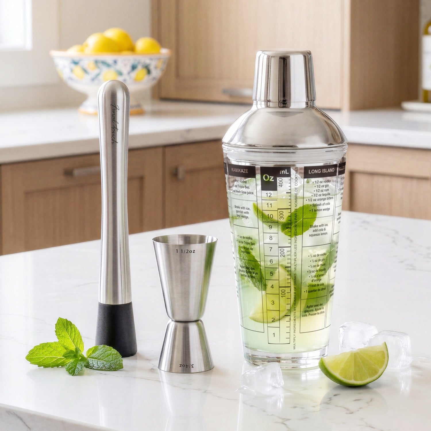 Final Touch 3-piece bar tools set with a completed cocktail inside the recipe shaker glass, flanked by a stainless steel muddler, double jigger, fresh mint, and lime wedges on a marble countertop.