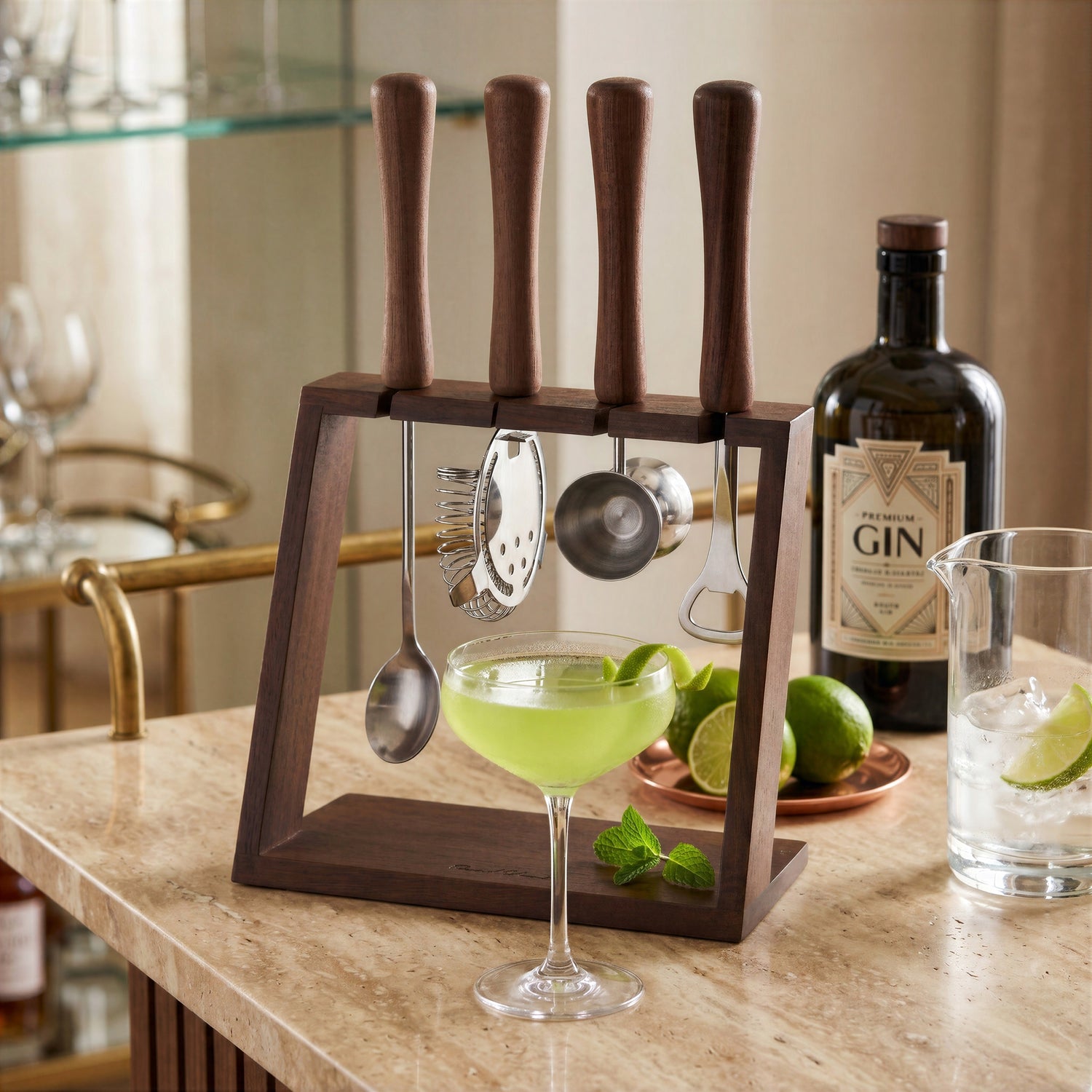 Final Touch acacia wood and stainless steel 5-piece bar tool set with stand, displayed on a marble countertop next to a green cocktail in a coupe glass, fresh limes, and a bottle of gin.