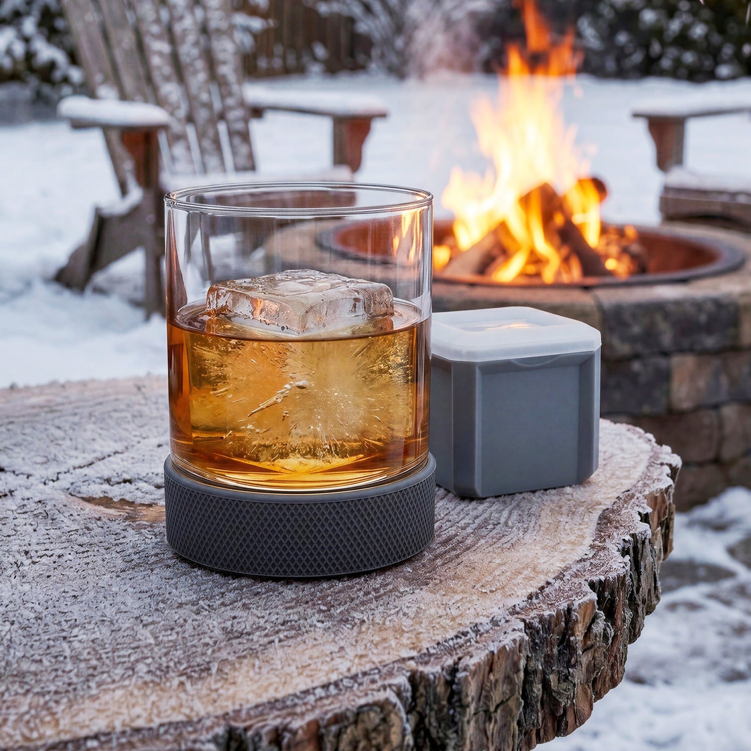 Final Touch Breakaway Hockey Puck Tumbler with Ice Mould on a frosty rustic table with a whiskey bottle by a winter backyard fire pit.
