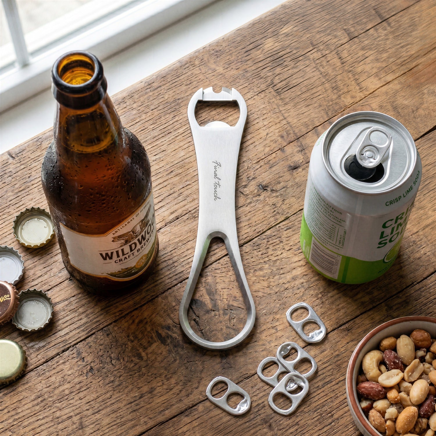 Final Touch ProBlade Plus Speed Bottle Opener on a rustic wooden table next to a craft beer bottle, soda can, and metal tabs.