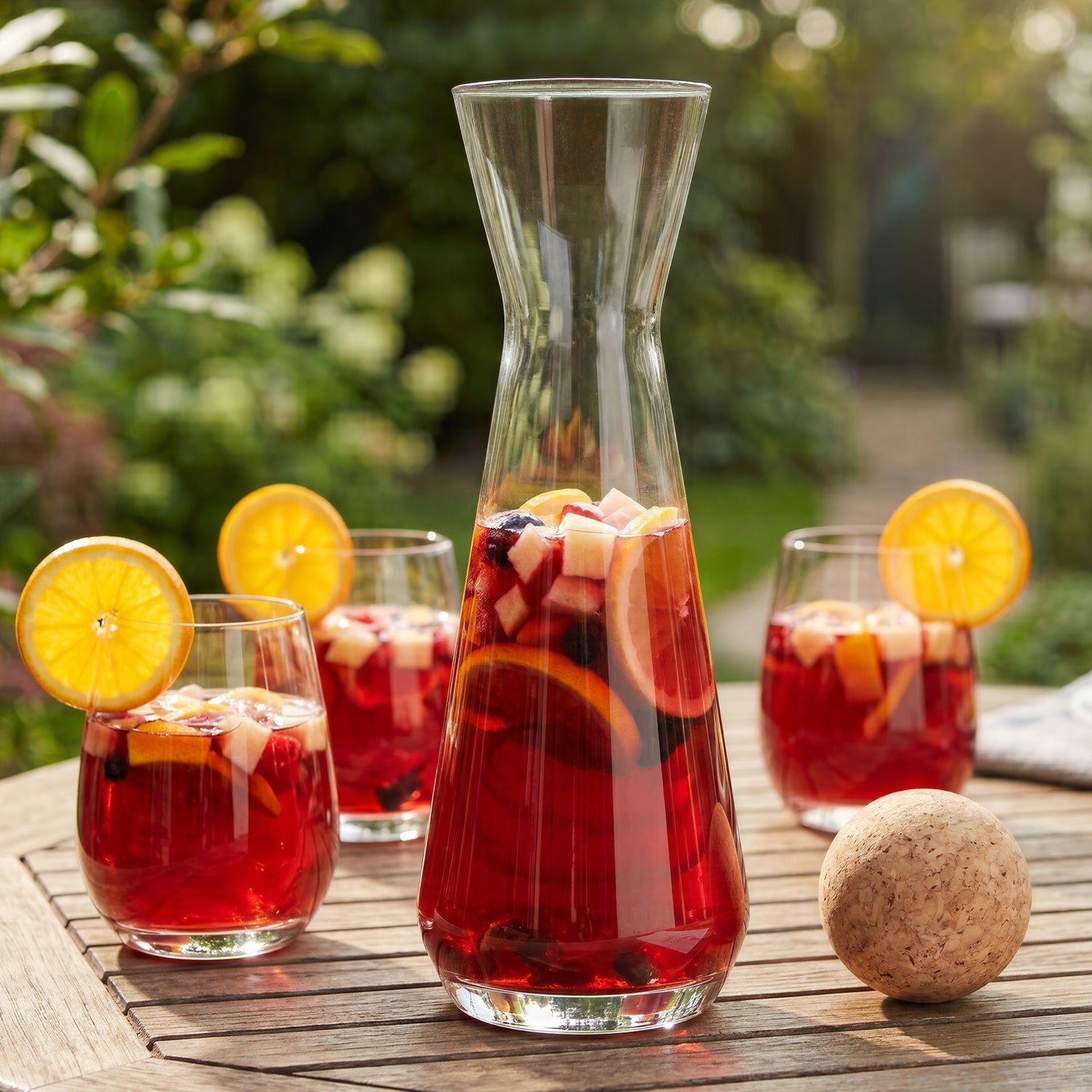 Final Touch glass sangria carafe with cork ball stopper next to matching stemless glasses filled with red wine sangria.