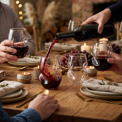 Four Final Touch Conundrum Stemless Red Wine Glasses on a rustic wooden table, highlighting the signature aerating curves and ergonomic thumb notch.