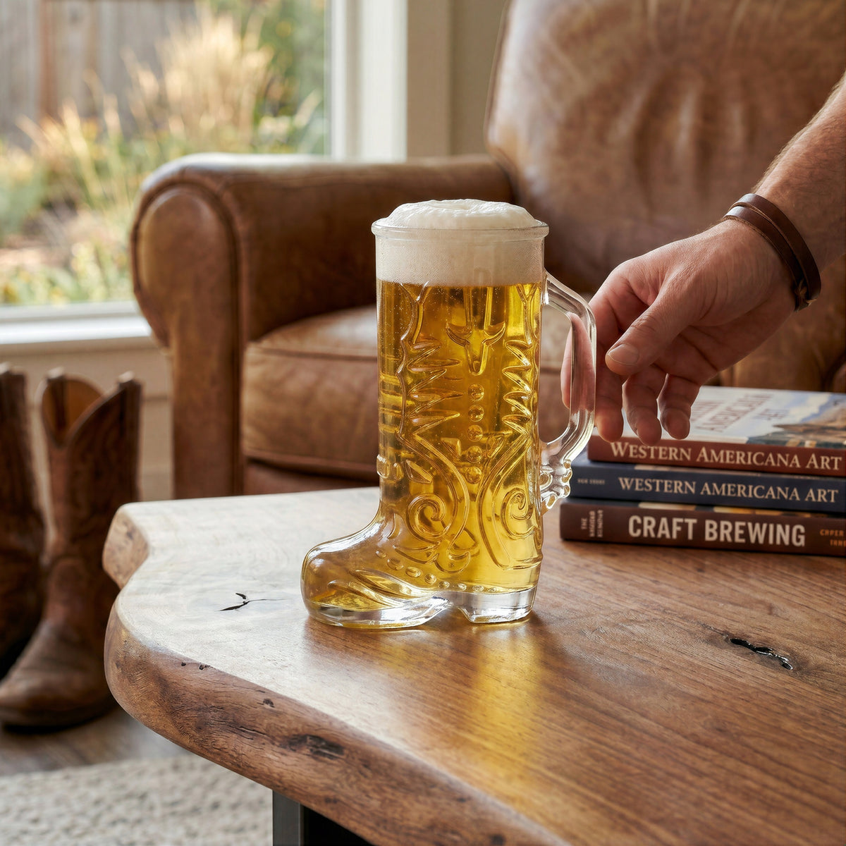 Final Touch Wild West Boot Glass filled with amber beer and foam on a rustic live-edge wooden coffee table in a cozy living room.